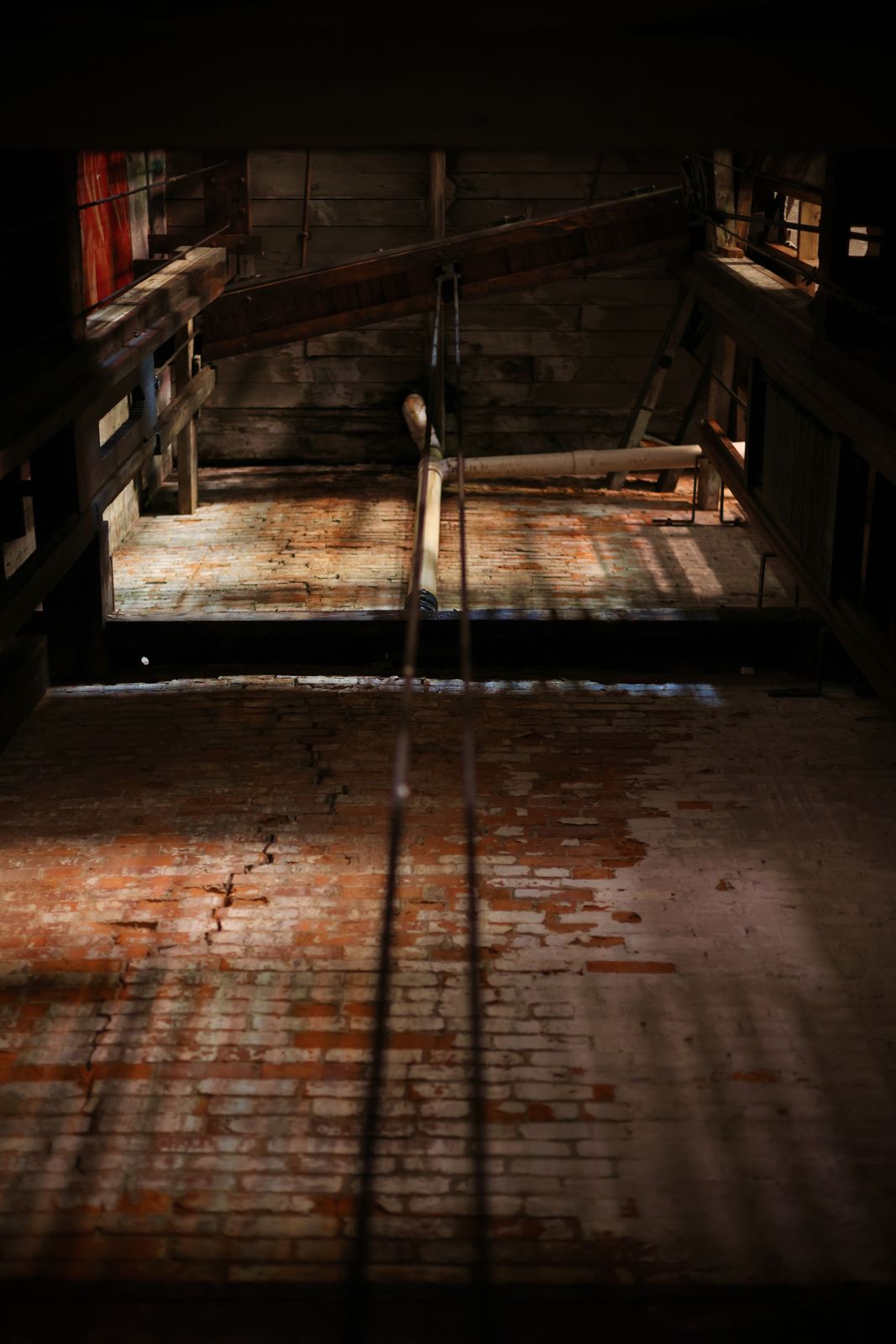 Heavy timber loft framing above a brick floor