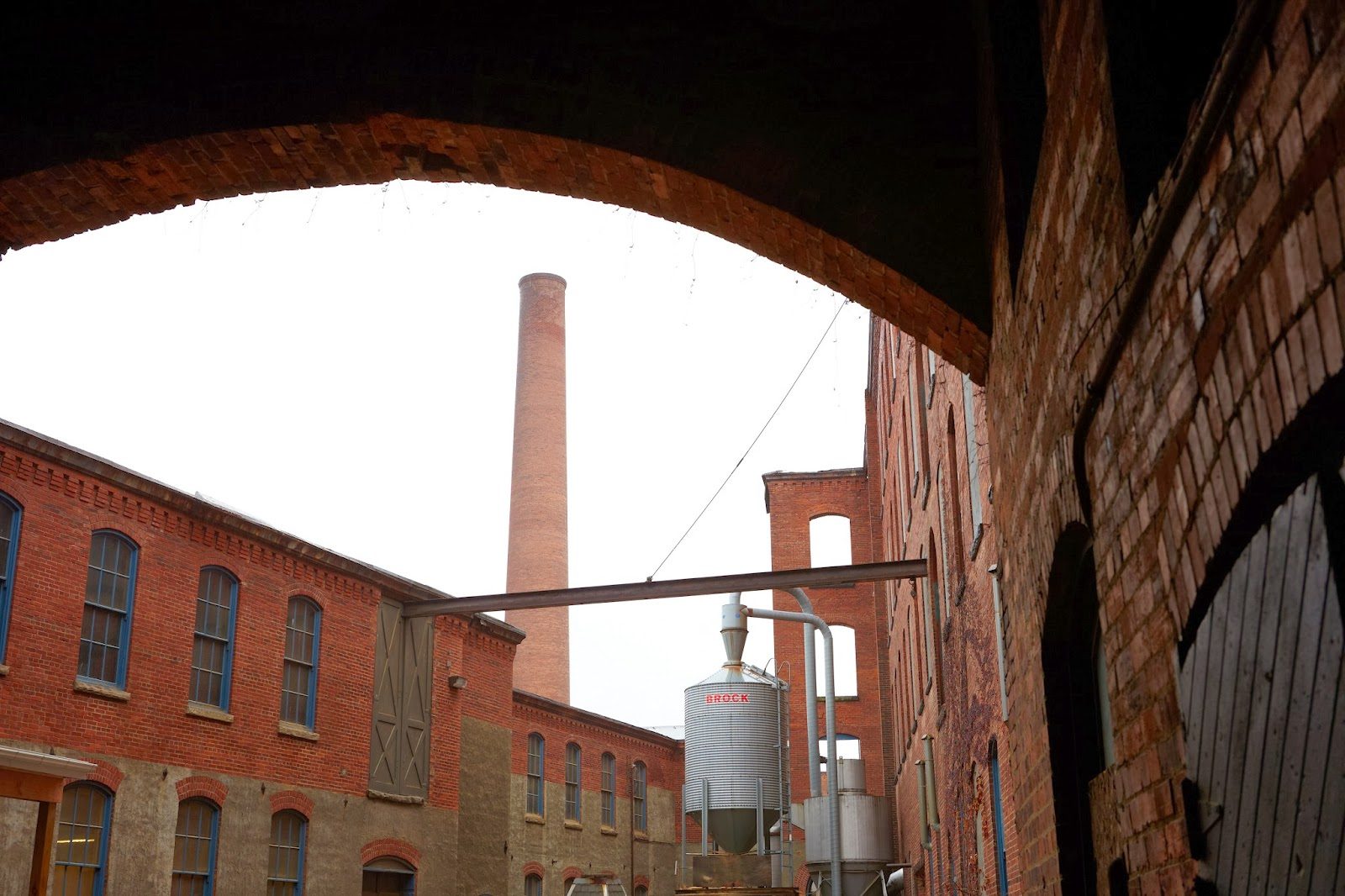 Chimney stack viewed through a brick archway