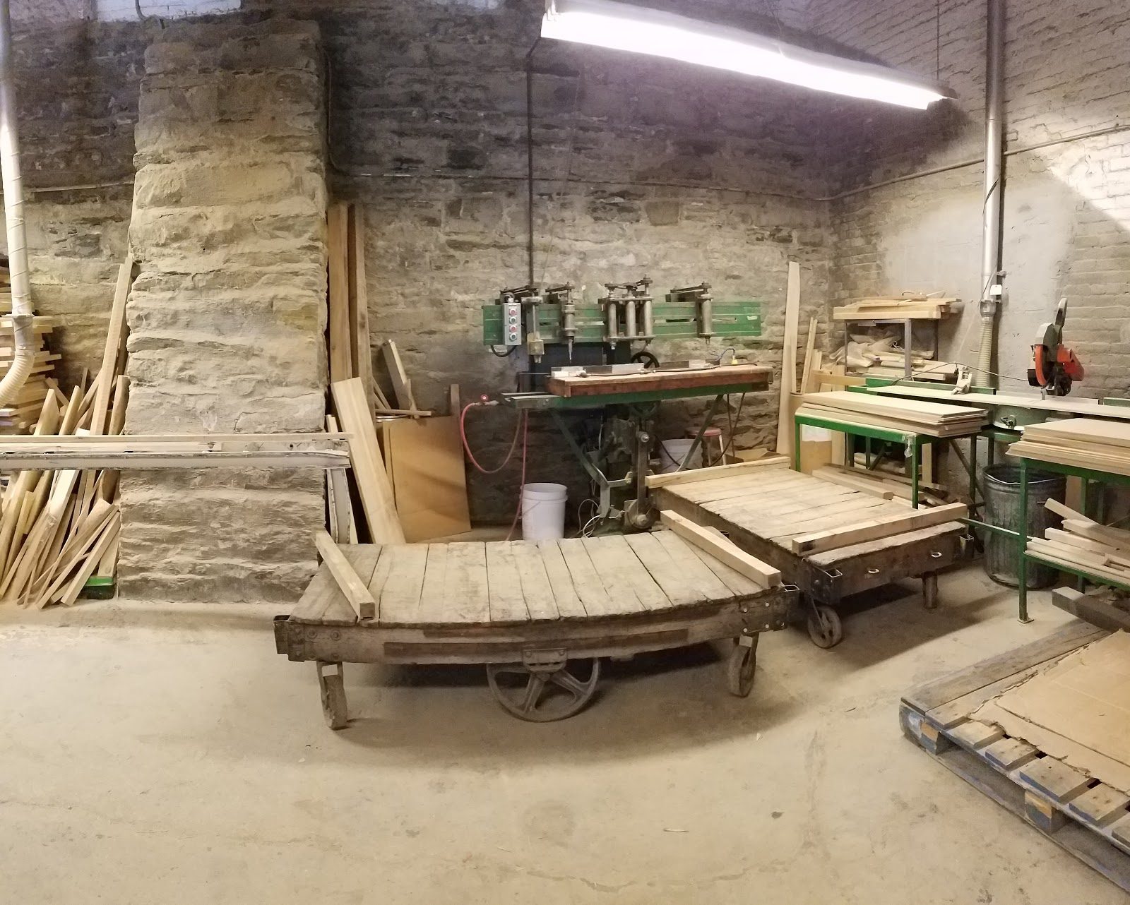 Basement workshop area with tool cart and stone walls