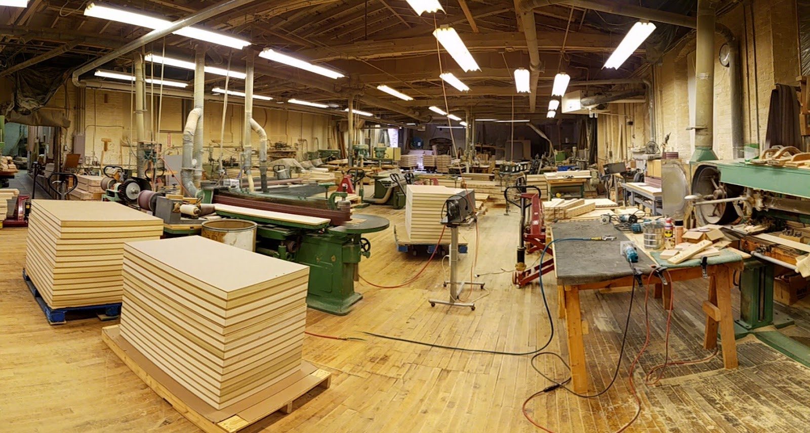 Woodworking shop floor with stacked panels and machinery
