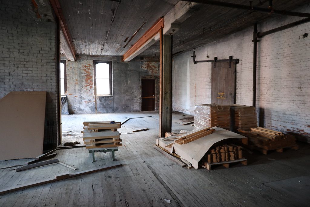 Lumber and crating stacked in an exposed brick bay