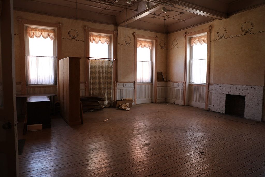 Front room with curtains, radiators and a fireplace