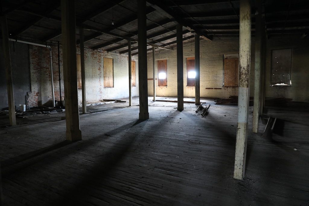 Arched-window hall with scaffolding and stored furniture