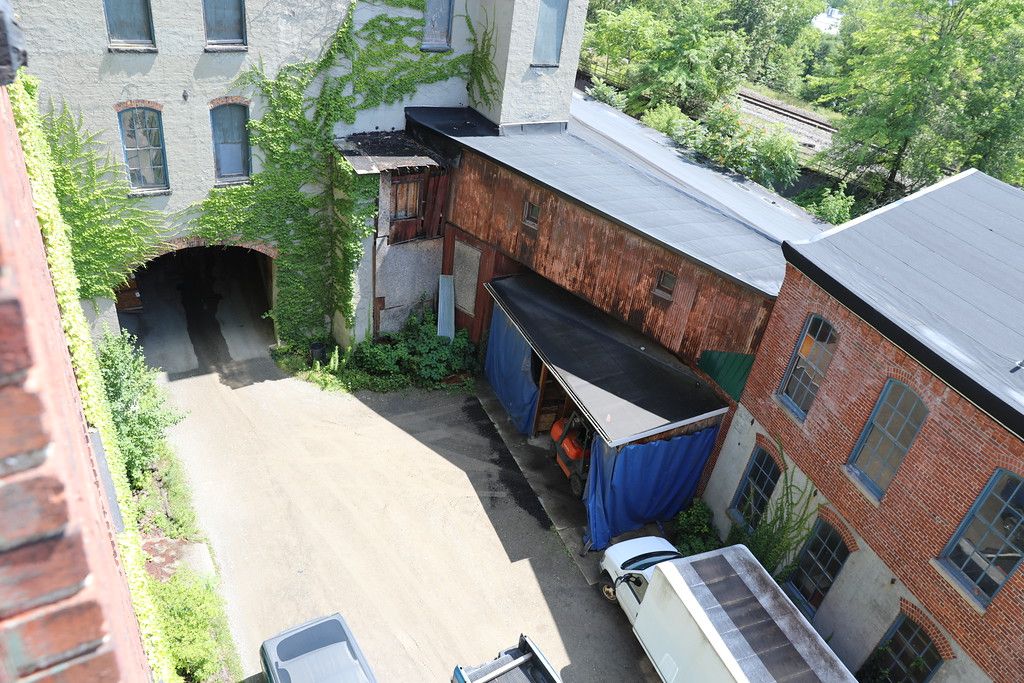 Ivy-covered archway seen from the roof, leading to a rear building