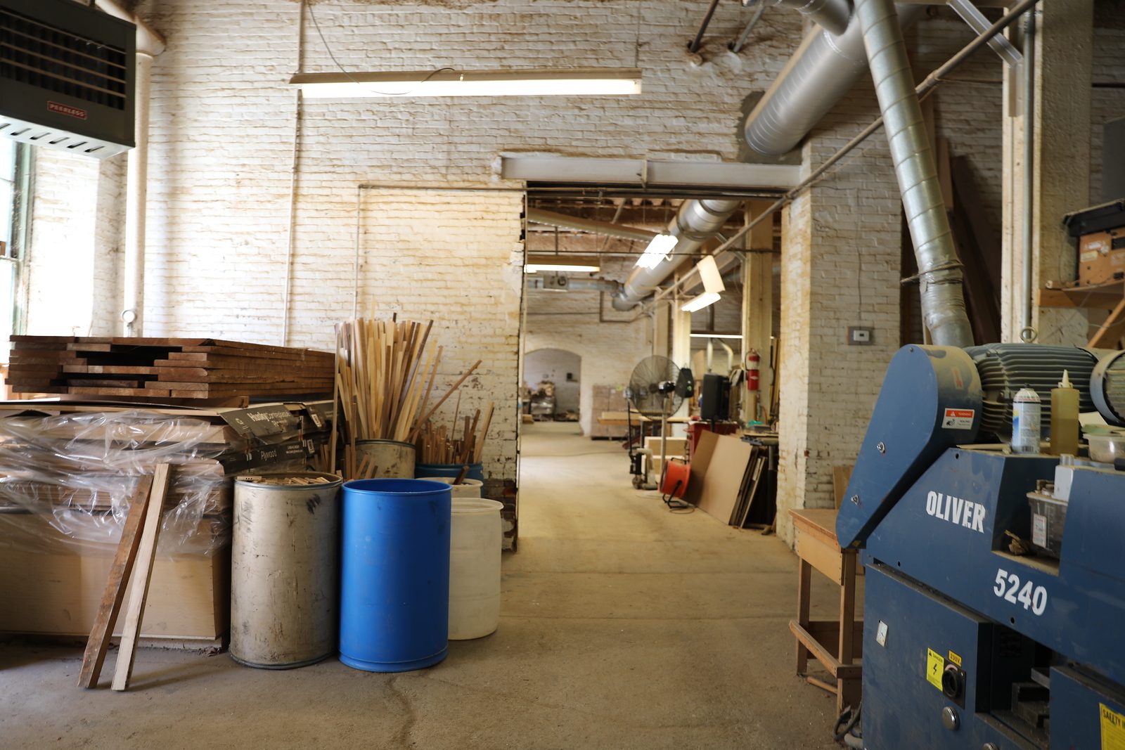 Shop floor with stacked lumber and an Oliver planer